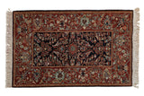 A hand-knotted Armenian Hamadan rug with a floral navy blue center and wide chestnut brown border.