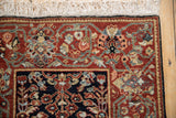Corner of a vintage Armenian rug showing the floral border, dense wool pile, and clean white fringe.