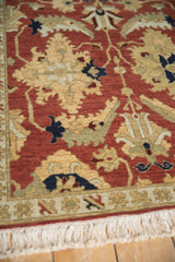 Angled view of the full wool pile, narrow border, and fringe on a vintage Armenian Sultanabad rug.