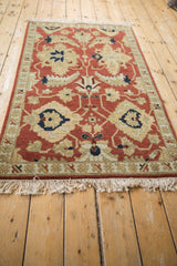 Full length perspective of the vintage Armenian rug's terracotta, sand, and navy blue pattern.