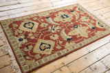 A vintage Armenian Sultanabad rug with a terracotta field viewed from an angle.