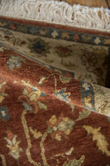 A close view of the full wool pile and ivory fringe on a rolled vintage Armenian Lilihan rug.