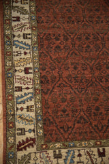 Fine wool pile showing the serrated leaf border and tone-on-tone rust trellis field.