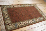 High-angle view of a vintage Armenian rug showing its rust tone-on-tone field and detailed borders.