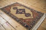 An angled view of the entire vintage Armenian Serab rug, showing its diamond medallion and full wool pile.