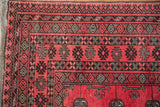 Close-up on the geometric borders in raspberry and charcoal, showing the rug's original side cord.