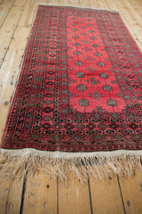 Angled view down the length of a vintage Daulatabad rug showing its repeating geometric guls.