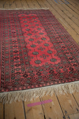 Angled view of a vintage Daulatabad rug's dusty raspberry field and geometric borders.