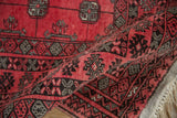 A vintage Daulatabad rug folded to show the plush pile and charcoal geometric border.