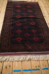 Close-up of vintage Pakistani Turkmen rug's dark brown, cherry red concentric serrated diamond medallions.