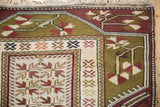 Corner view of a vintage Turkish Melas rug showing its full pile and geometric arrowed blossoms.