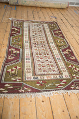 High-angle view showing the full length and reciprocating geometric pattern of a vintage Melas rug.