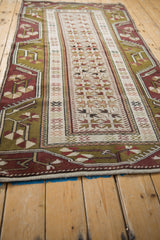 Angled view down the length of a vintage Melas rug, showing its full pile and geometric pattern.