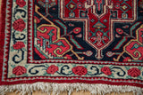 Close-up on the full pile corner of a vintage Bijar rug, showing the intact selvage and fringe.