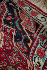 Folded vintage Bijar rug revealing its full, dense wool pile and sapphire blue details.
