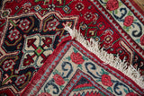 A folded corner of the vintage Persian Bijar rug reveals its hand-knotted back and clean ivory fringe.