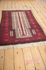 Ivory fringe and cherry red border with detailed geometric motifs of the Belouch rug.