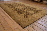 Angled view of the Indian Oushak carpet's lustrous pile and brown floral design.