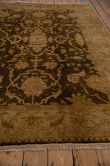 Angled view across the lustrous, plush wool pile of a chocolate brown and gold Oushak carpet.