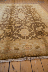 Low angle view of the Indian Oushak carpet's lustrous wool pile and gold floral patterns.