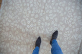 Contemporary hand woven Soumac rug with ivory dancing leaf pattern and abrashed sand ground.