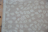 Contemporary Indian Soumac carpet detail, textured ivory leaf pattern on a pale sand field.