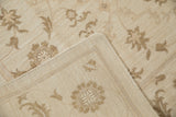 Cream Indian Soumac carpet with pale coffee brown Rococo floral arabesques and side selvage.