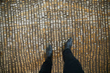 Hand knotted abstract Indian carpet with asymmetric gold, ivory, and chocolate patterns.