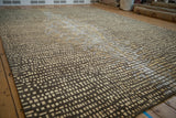 Intricate abstract square pattern of the Indian rug in chocolate, gold, and ivory tones.