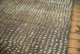 Asymmetric gold, ivory, and chocolate brown squares on the abstract rug.
