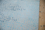 Abstract Indian carpet with ivory pile and varying powder blue, dusty teal squares.