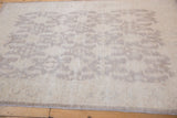 Peshawar rug's soft ivory pile with subtle oxidized silver geometric medallions.
