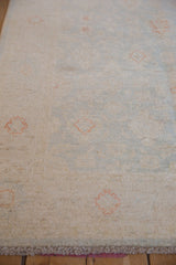 Hand knotted Peshawar rug pile with ivory, pale blue, and terra cotta floral motifs.
