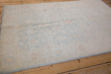 Peshawar rug showing pale copper floral blossoms on an ivory and ice blue field.