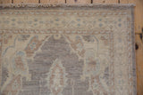 Peshawar runner corner, hand-knotted, full ivory pile, fringed, with muted silver and blue patterns.