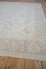 Close-up of Peshawar carpet main border featuring pale lotus flowers and fringed edge.