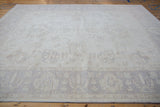 Ivory Peshawar carpet showing pale beige lotus border with delicate vinery.