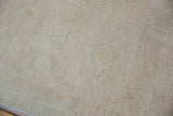 Soft pile texture of the Peshawar carpet, featuring antique ivory and pale wheat tones.