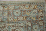 Hand-knotted Peshawar carpet corner with pale seafoam, blue, and copper curvilinear motifs.