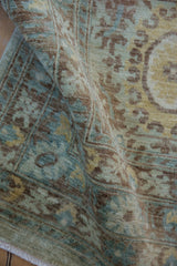 Curved Peshawar carpet pile, highlighting Aubusson inspired motifs in seafoam green, blue, and brown.