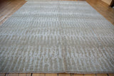 Lustrous pile of a contemporary hand knotted rug, showing nuanced silver and slate blue elongated design.