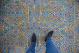 Close-up of contemporary Pakistani rug, geometric Persian design in slate blue, aqua, saffron.