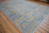 Contemporary Pakistani carpet featuring geometric Persian motifs in slate blue, saffron, and cochineal red.