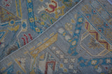 Hand-knotted rug detail: geometric pile, woven back, and selvage in silver, blue, yellow.