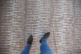 Feet on soft simulated silk pile, contemporary Pakistani rug, silver and powder blue design.