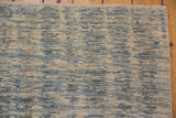 Striated ivory, powder blue, and slate abrashes on a Contemporary Pakistani rug, with fringe.