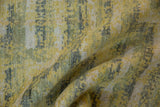 Folded contemporary Pakistani rug pile, saffron yellow and oxidized silver tones.