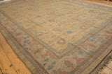 Indian Soumac carpet corner showcasing dusty gold field, blush floral motifs, and geometric borders.