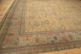 Dusty gold Soumac rug corner with arabesque, lotus, and pawn design borders.