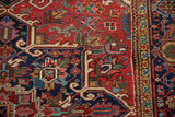 Detail of a vintage Heriz corner with stylized samovar finials in navy blue, red, and beige.
